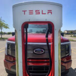 A Ford F-150 Lightning at a Tesla Supercharging station. Ford to Adopt Tesla's NACS.